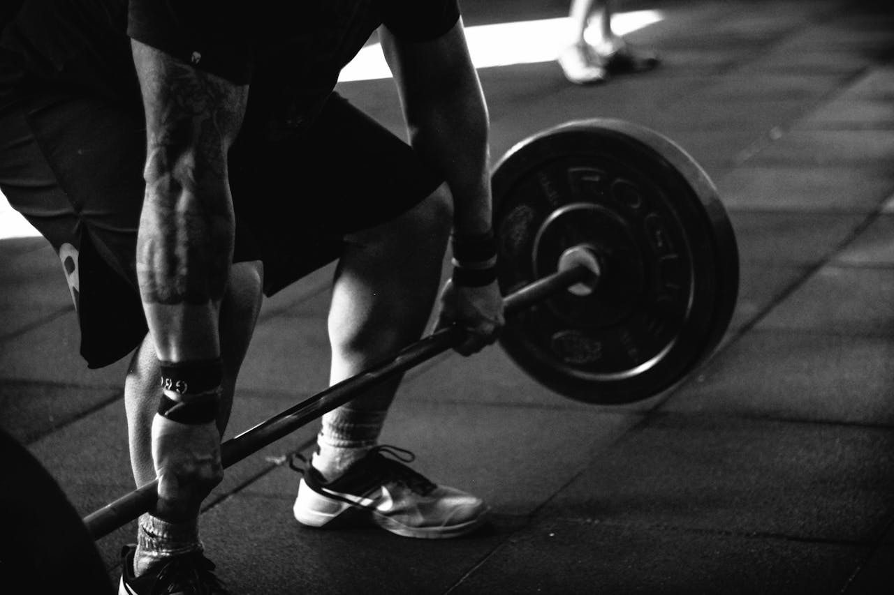 home-hero A powerful black and white image of a man deadlifting in a gym, showcasing strength and fitness.